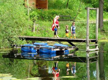 Oma mit Enkeln beim Teich